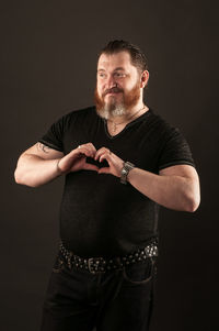 Midsection of man standing against black background