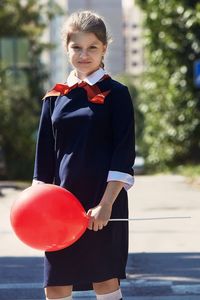 Portrait of smiling young girl holding balloon