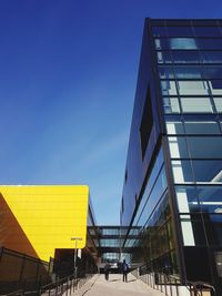 Low angle view of modern buildings against clear blue sky
