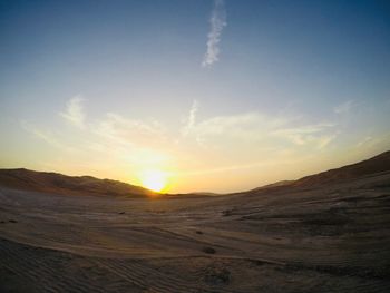 Scenic view of desert against sky during sunset