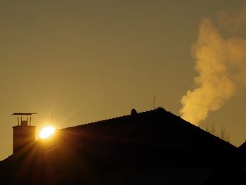 Silhouette buildings against sky during sunset