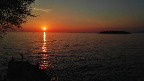 Scenic view of sea against orange sky