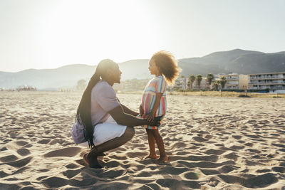 Happy man with daughter at beach on sunny day