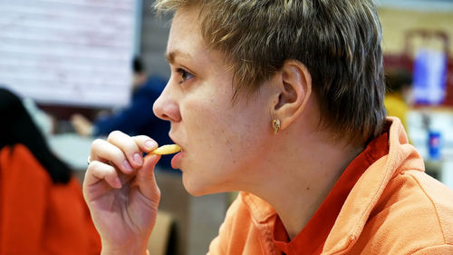 Close-up of woman eating french fries at restaurant