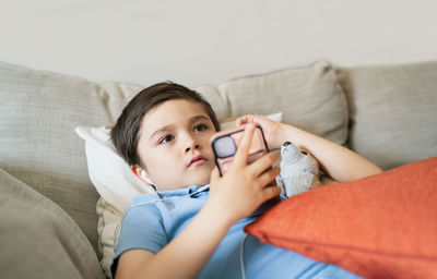 Portrait of boy lying on sofa at home