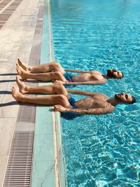 Low section of man swimming in pool