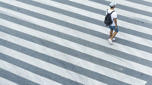 Low section of woman walking on zebra crossing