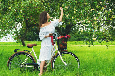 Rear view of woman riding bicycle on field