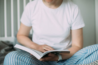 Midsection of woman reading book