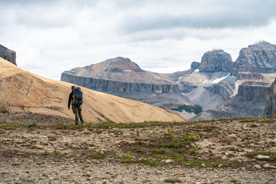 Hiker observing remote mountain peaks in distance