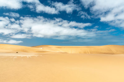 Sand dunes in desert against sky