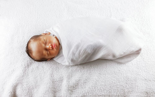 High angle view of baby sleeping on bed
