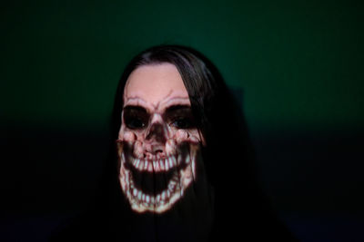Close-up of spooky woman against green background