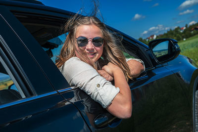 Portrait of smiling young woman in car