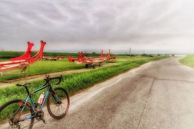 Bicycle by road against sky