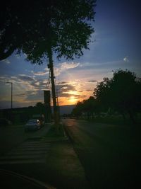 Cars on road against sky during sunset