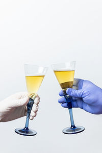 Close-up of hand holding drink against white background