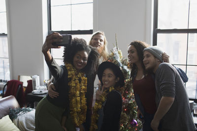 A group of people taking a photo with a christmas tree