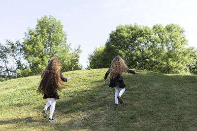 Rear view of woman standing on grassy field