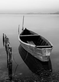 Boat moored on lake against sky