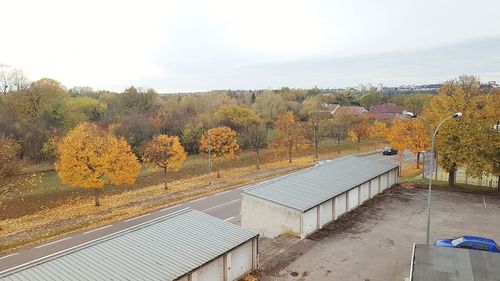 High angle view of trees by building against sky