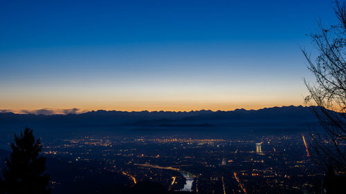 Scenic view of cityscape against clear sky at sunset