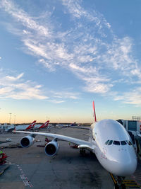 Airplane on airport runway against sky