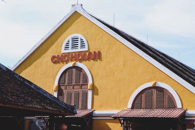 Low angle view of yellow building against sky