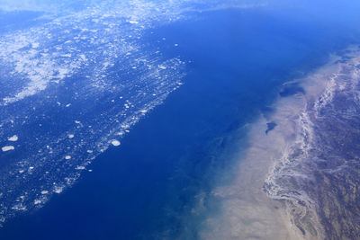 Aerial view of sea against blue sky