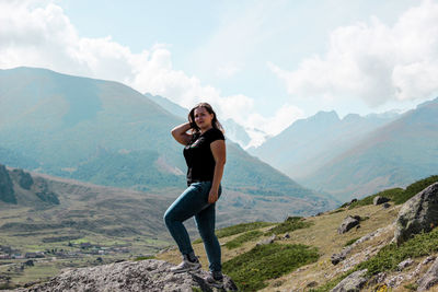 Portrait of woman standing on rock against mountain range