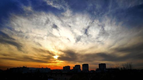 Silhouette buildings against sky during sunset