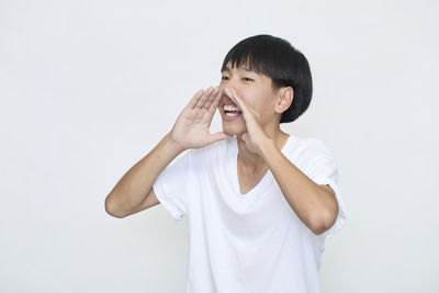 Smiling boy standing against white background