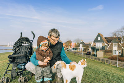 People with dog against sky