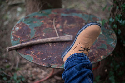 Low section of man foot on rusty metallic table