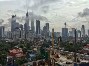 View of cityscape against cloudy sky