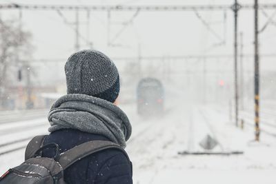 Man in warm clothing standing on railroad station platform