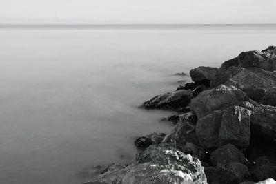 Scenic view of rocks on sea against sky