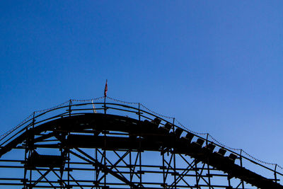 Low angle view of ferris wheel against blue sky