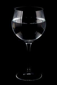 Close-up of wine glass against black background