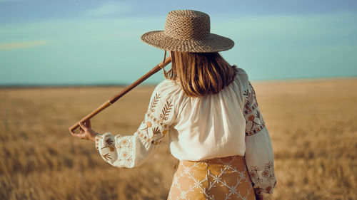 Rear view of woman standing against sky