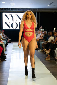 Full length portrait of young woman standing on floor