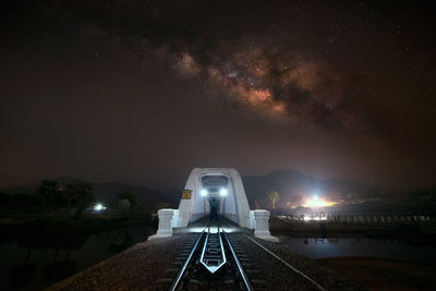 Illuminated bridge against sky at night