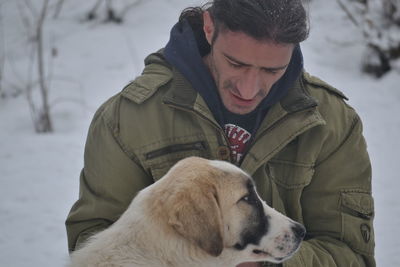 Close-up of man with dog during winter