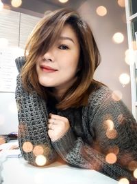 Portrait of smiling young woman sitting at home