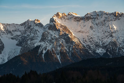 Low angle view of snowcapped mountains against sky