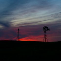 Low angle view of silhouette windmill against sky during sunset