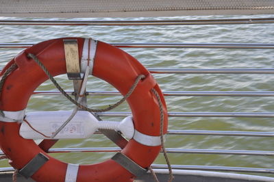 View of life belt on railing of sailboat against sea