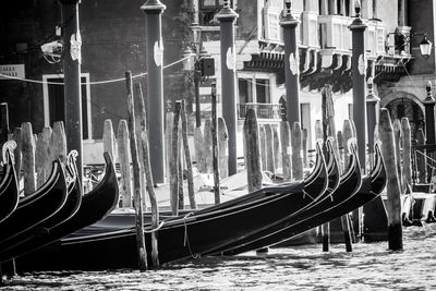 Gondolas moored in grand canal against building on sunny day