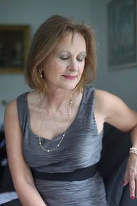 Well-dressed senior woman with eyes closed sitting at home