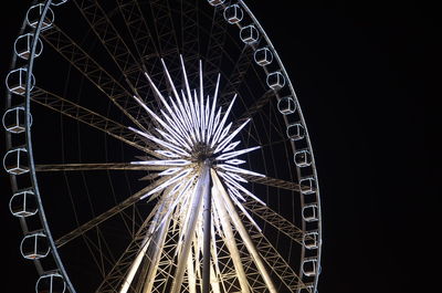 Low angle view of illuminated ferris wheel at night